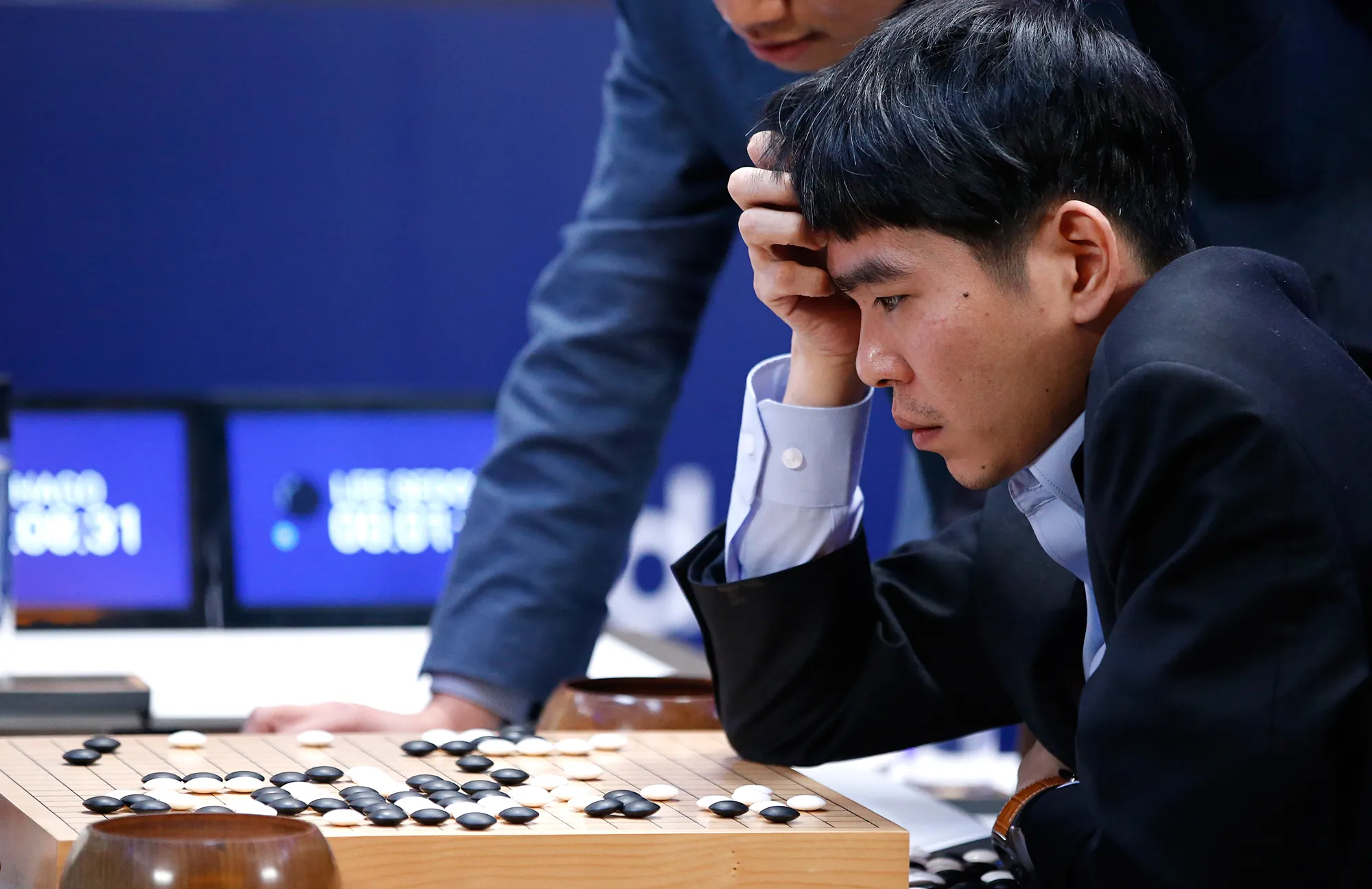 Go champion Lee Sedol resting his head on his hand, studying the board during his match against AlphaGo.