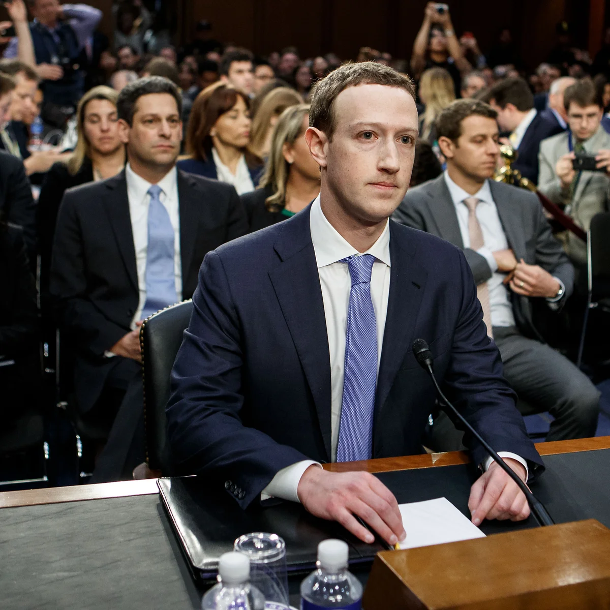 Mark Zuckerberg seated to testify before the US Senate amid a wall of press photographers.