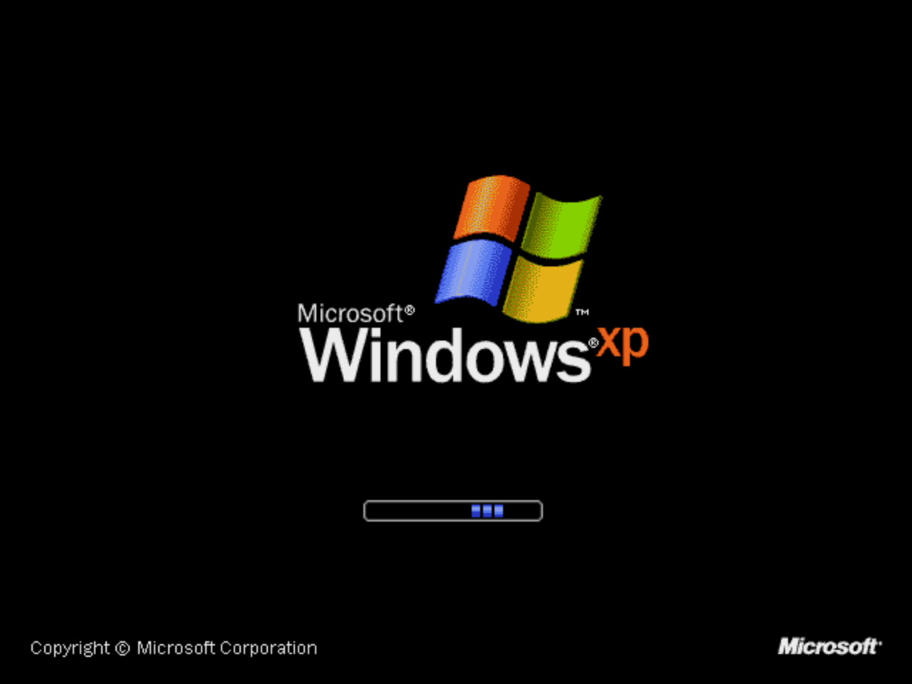 The Microsoft Windows XP logo and wordmark glowing on a black boot screen.